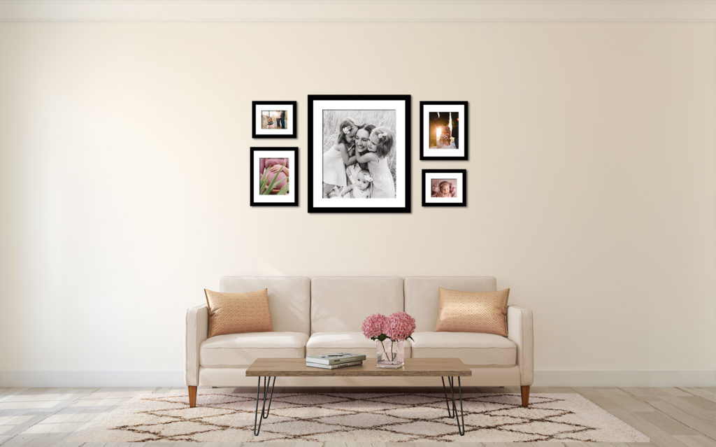 Wall art gallery of beautiful framed family photos hanging above couch in Boise home