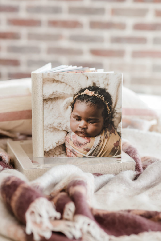 Heirloom photo album arranged on pink cloth showing newborn girl