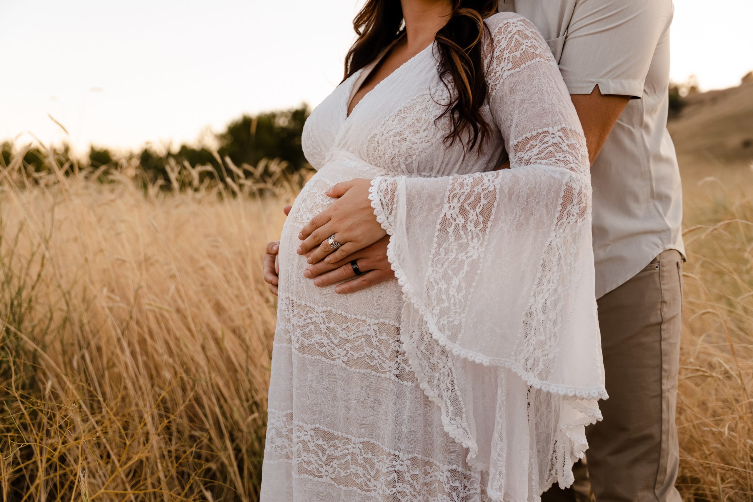 Outdoor maternity photo of pregnant couple in field