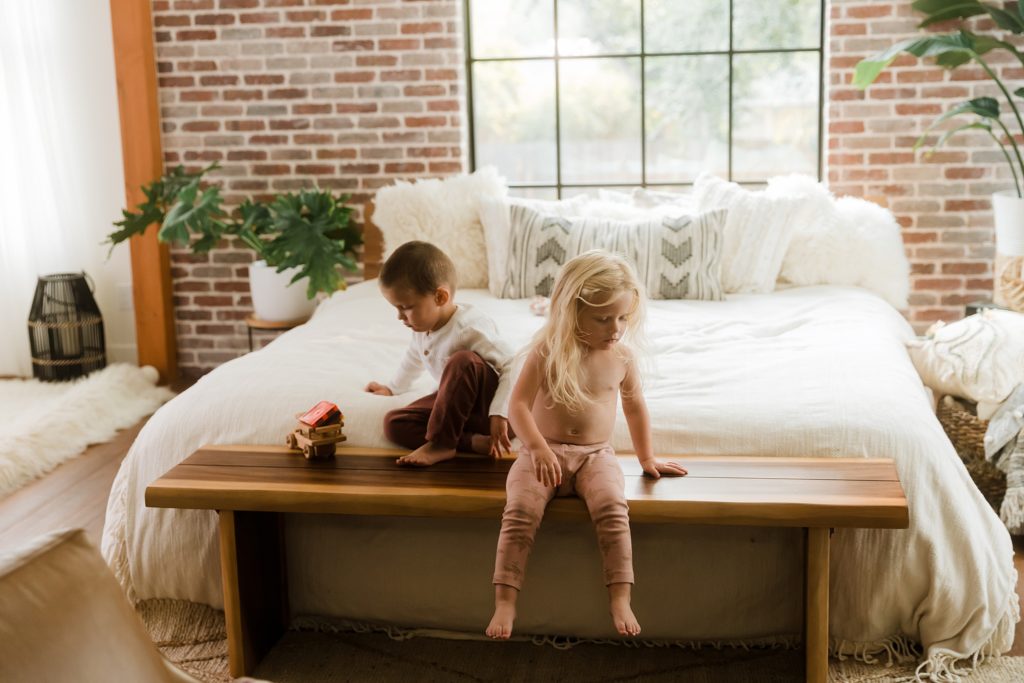 Twin boy and girl sitting on bed together in Boise Idaho studio