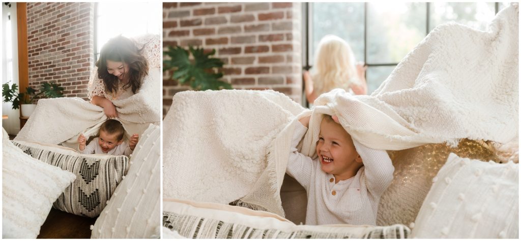 Little boy smiling from under blanket fort -- Motherhood photography sessions in Boise Idaho
