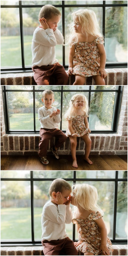 Two-year-old twin boy and girl sitting on windowswill