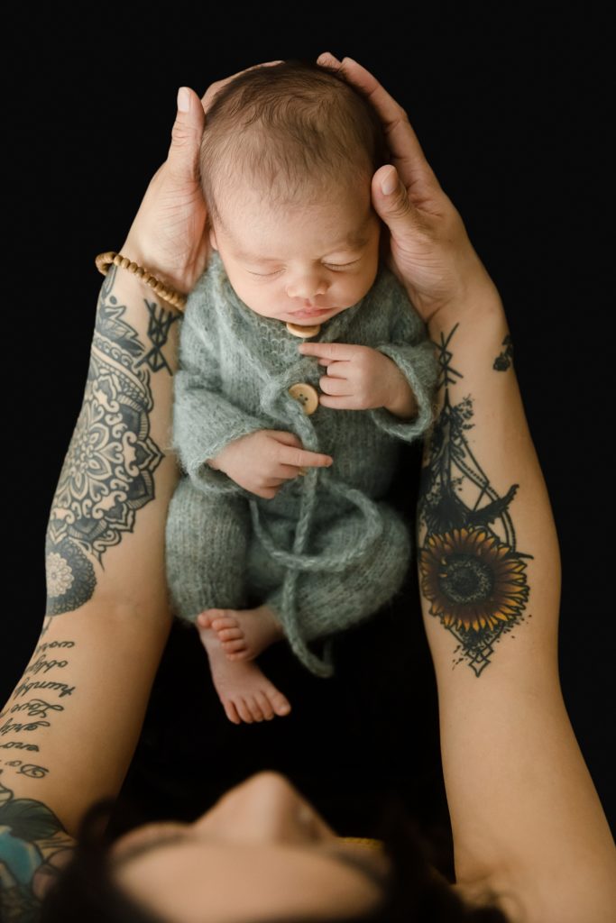Mother with tattoos holding new baby