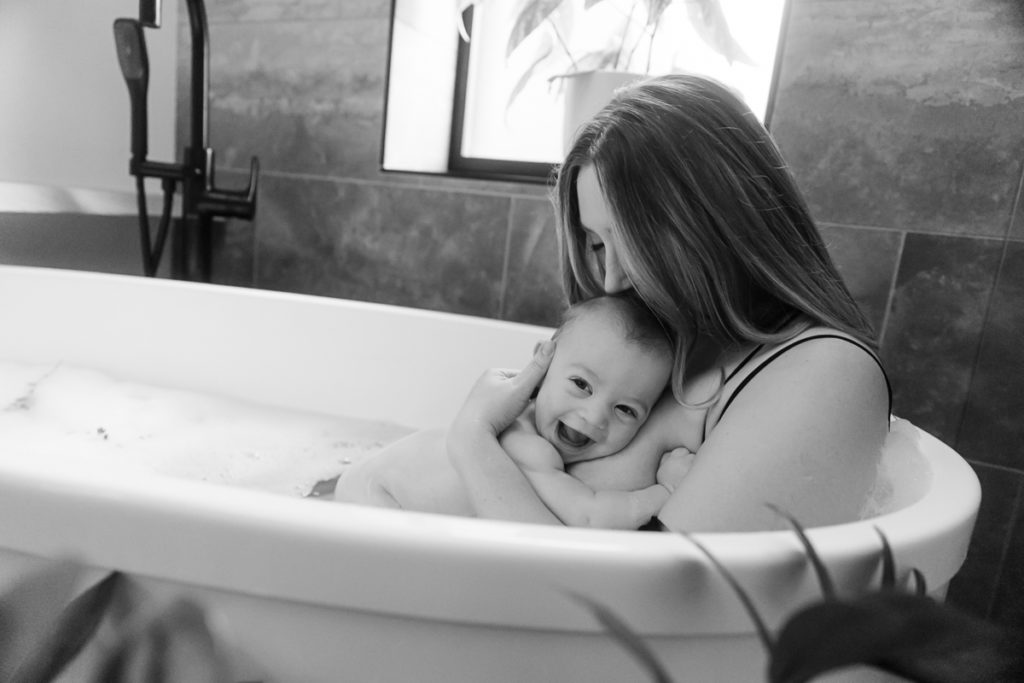 Mom hugging baby in bath