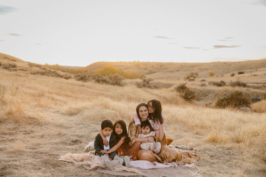 Mother sitting on blanket with children in Boise foothills