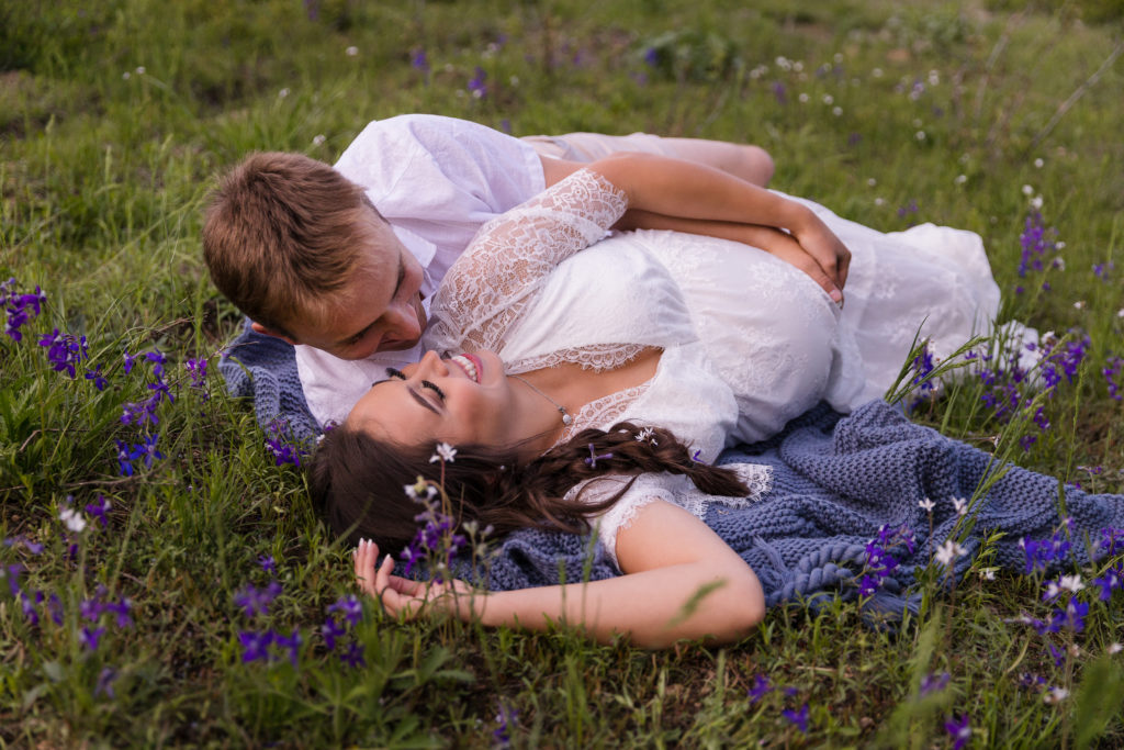 Couple lying on blanket amid spring flowers