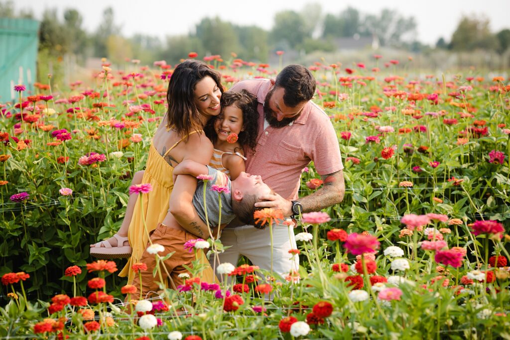 Parents playing with children in field of bright flowers at a flower farm near Boise Idaho
