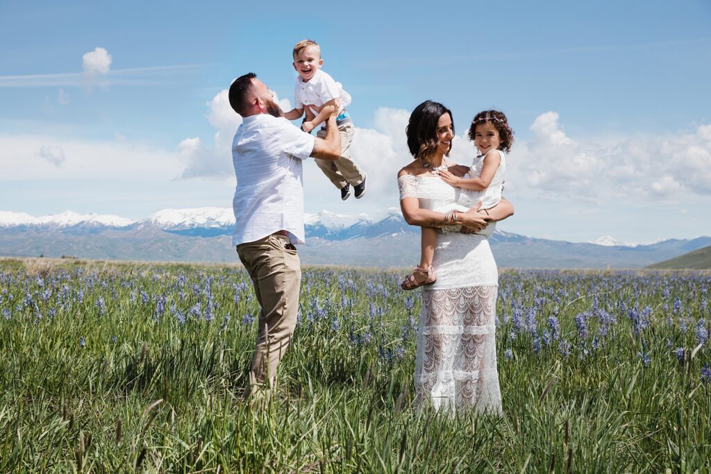 Parents playing with children in field of wildflowers in Fairfield, Idaho