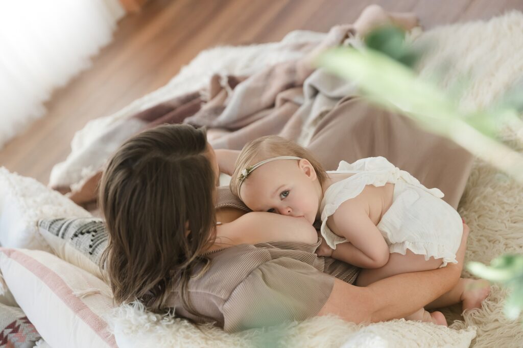 Boise breastfeeding portraits, baby girl curled up against mom while she nurses