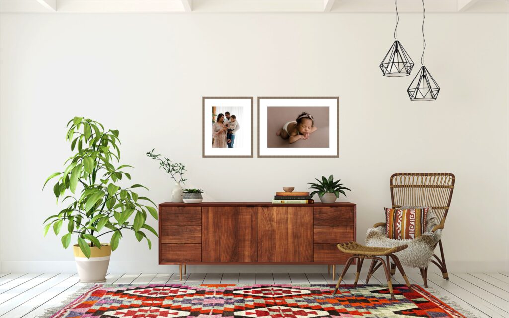 Framed newborn prints hanging above hall table in living room