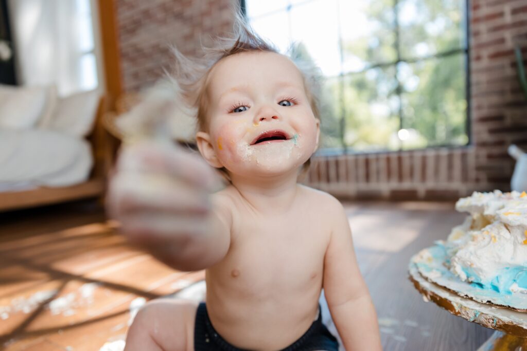 Baby boy enjoying first birthday cake smash in Idaho photography studio