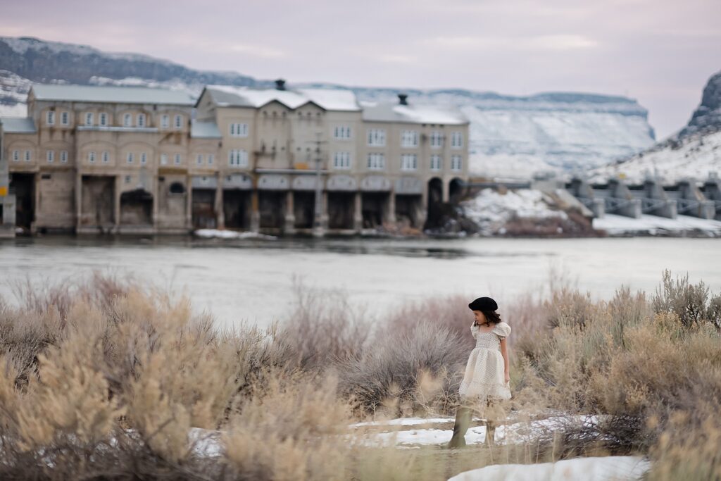 Little girl in white dress and beret walking near Swan Falls Dam in Idaho