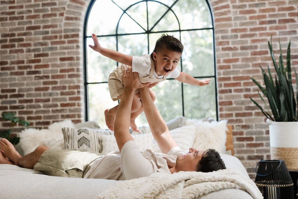 Father lifting older child in airplane position