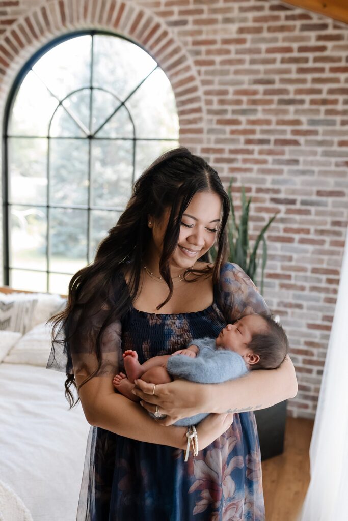 New mother cradling newborn baby in her arms