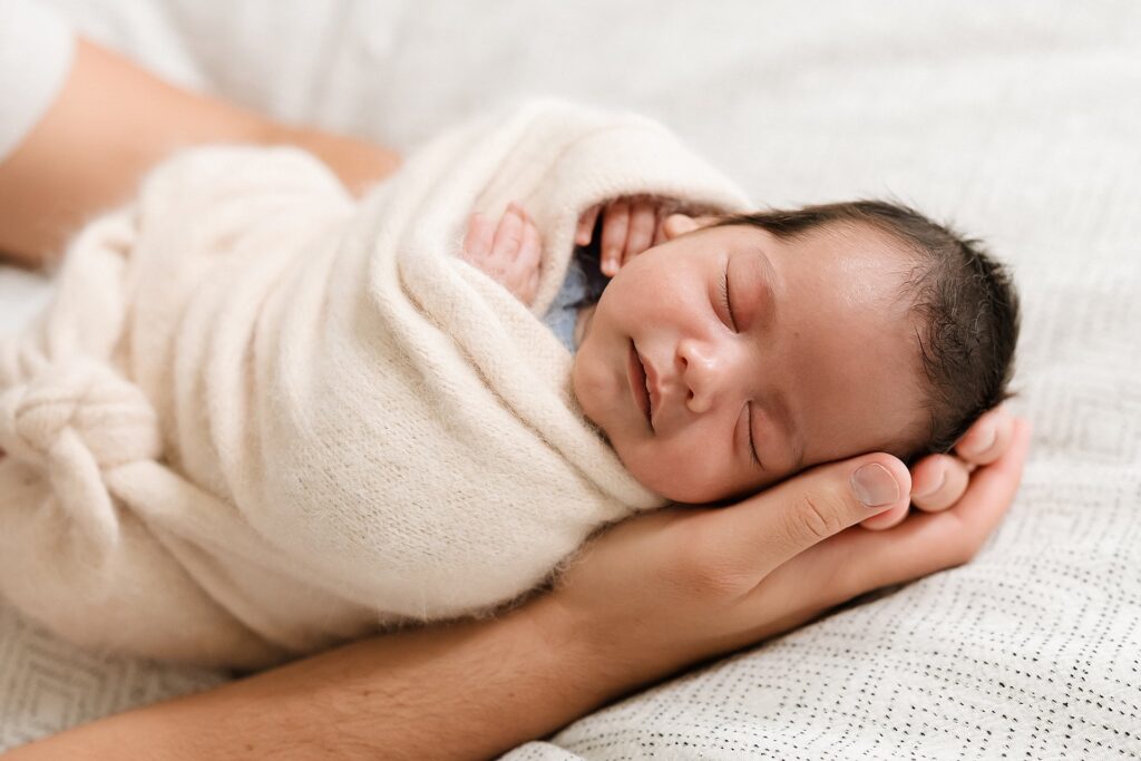 Close-up of newborn features in a parents hands