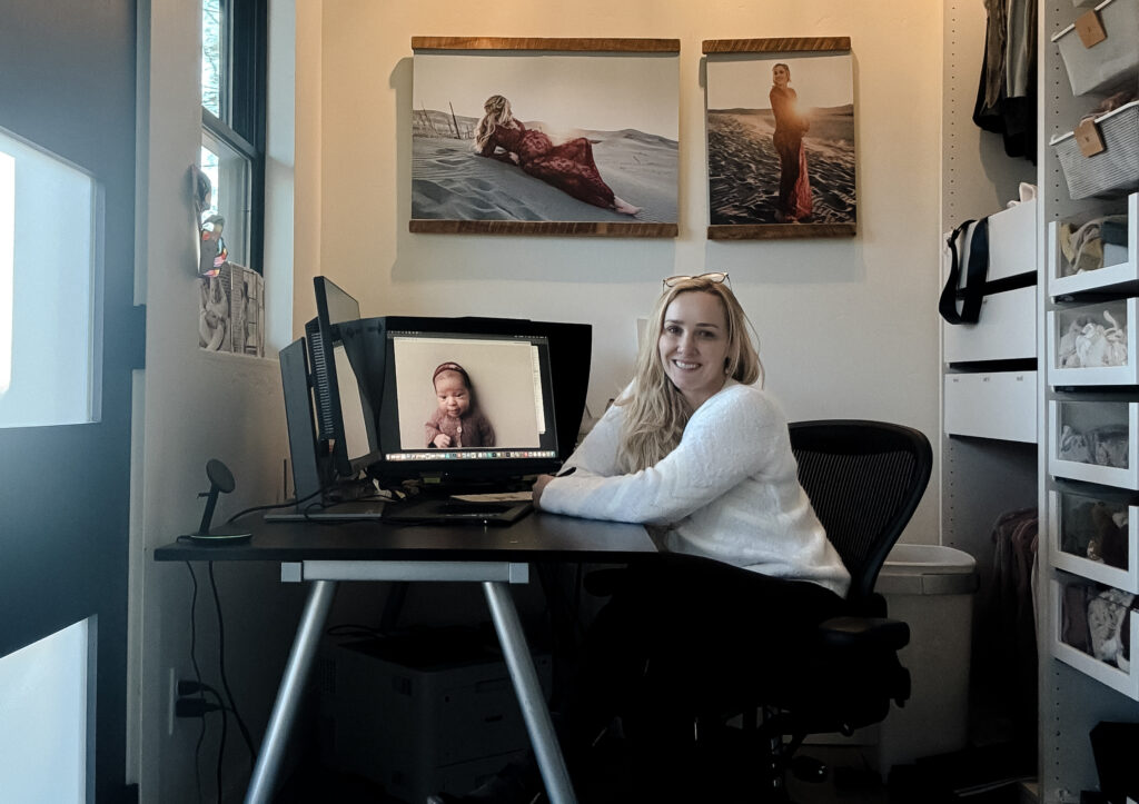 photoshop editing and newborn photography educator Paige McLeod, sitting at her desk to retouch. 