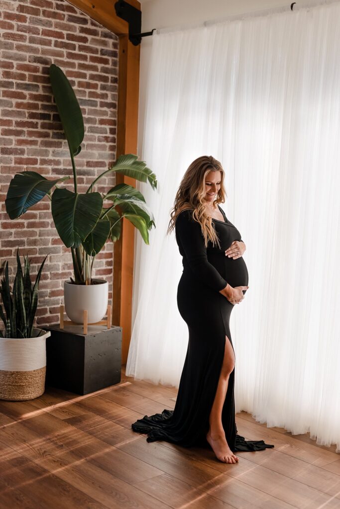 Classic maternity photo outfit featuring a timeless fitted black dress highlighting the beautiful pregnancy silhouette