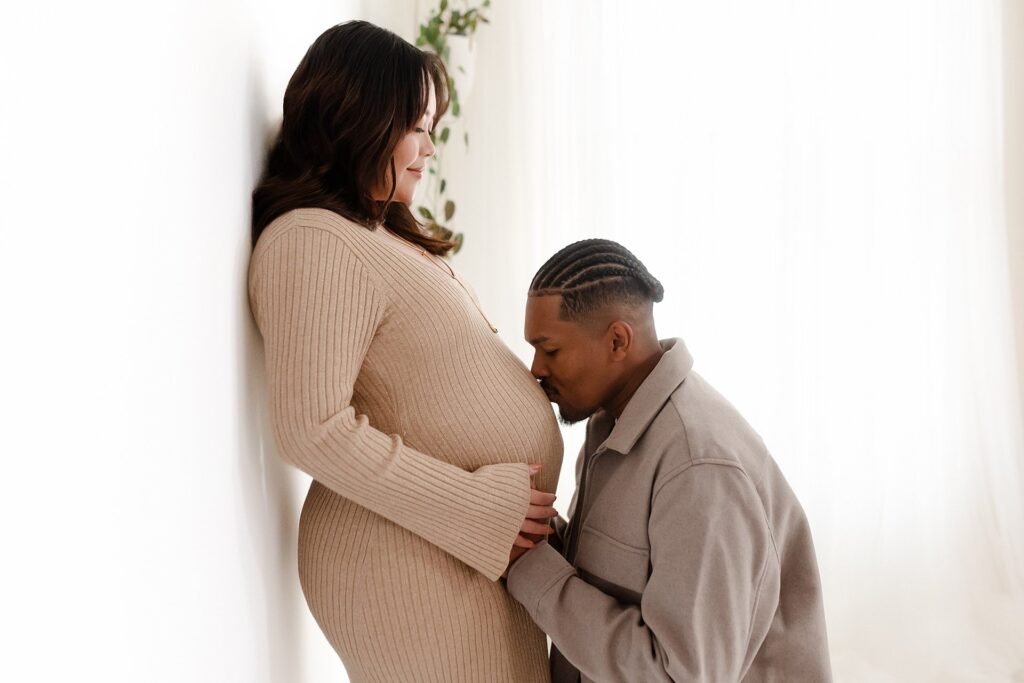 Couple's maternity portrait featuring mother-to-be in a fitted soft gold sweater dress, perfect for fall and winter maternity photos