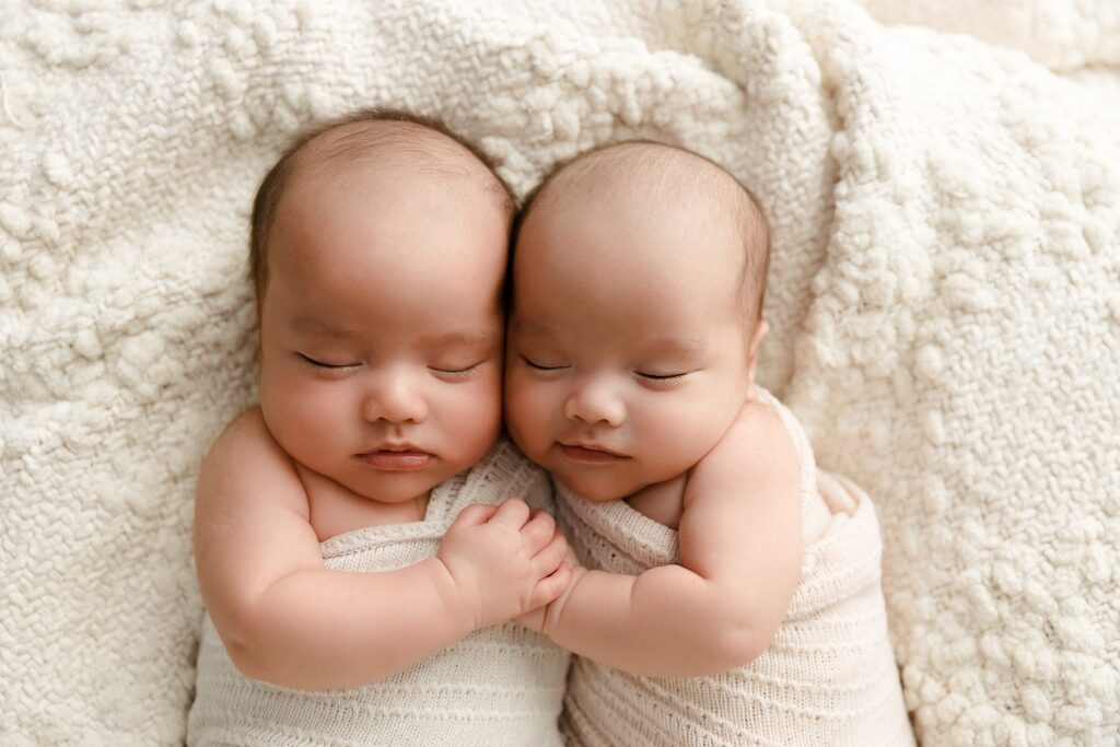Twin newborn babies sleeping peacefully during professional newborn photography session in Boise Idaho