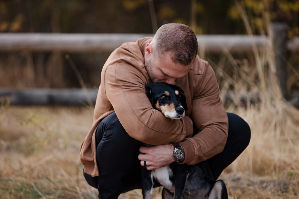 a dad hugs the family dog during a fall family photoshoot with glean and co photography in Boise idaho