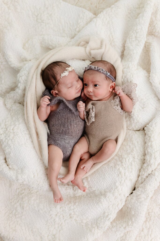 a blanket puddle on the floor for twin girls, an example of a safe way to DIY twin newborn photos 