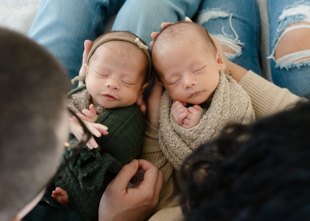 an overhead photo of newborn twins held in their parents arms in Boise Idaho photography studio