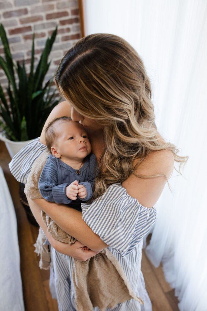 Mother tenderly holding her newborn during relaxed newborn photography session with Glean and Co
