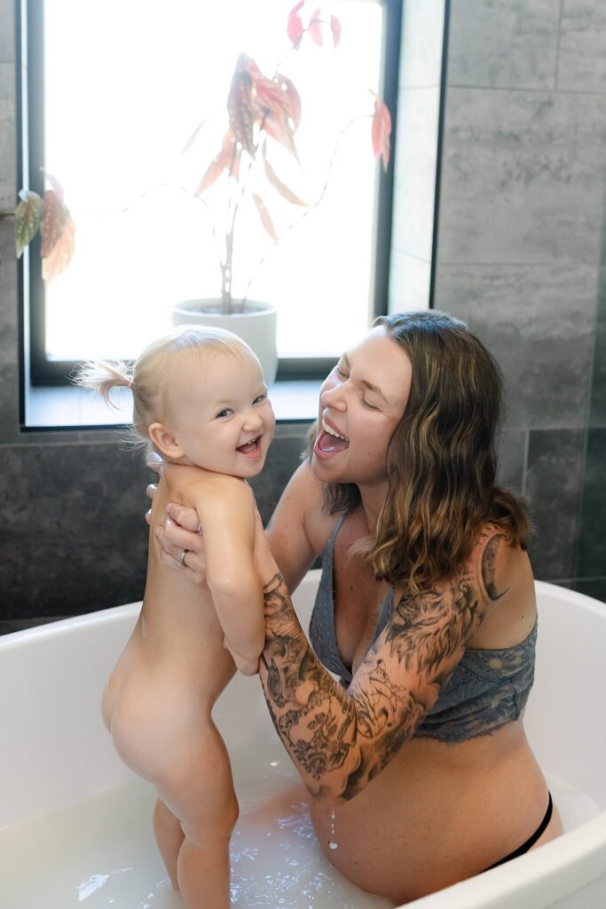 Intimate breastfeeding photography session capturing mom breastfeeding toddler in organic milk bath with fresh flowers by Glean and Co Photography Boise