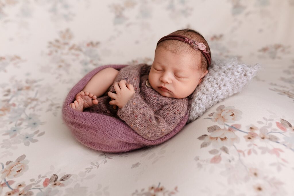 newborn photographer near me, Glean & Co Boise Idaho photography image of a newborn baby girl in purple tones on a floral background