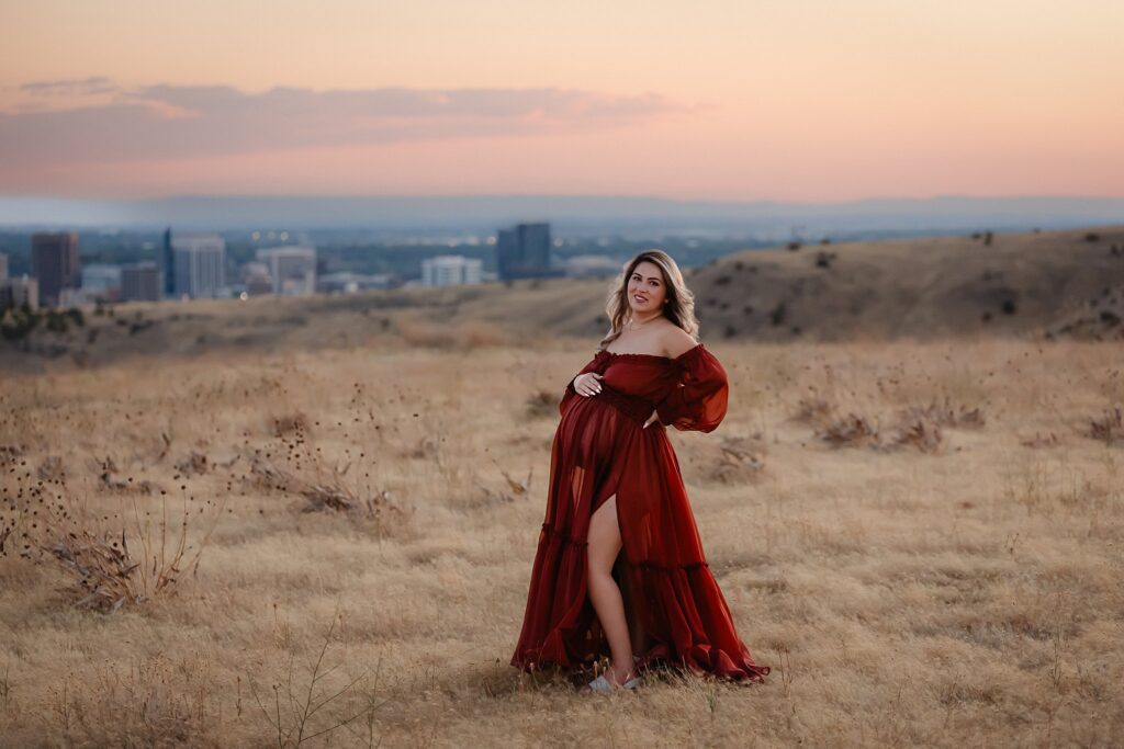 treasure valley maternity portraits in a stunning 2 piece reclamation dress, looking over the boise skyline at sunset