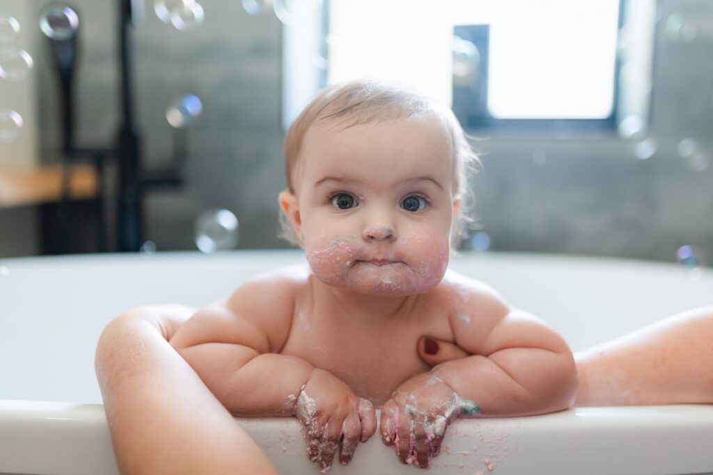 baby girl in a bubble bath during milestone photos at Glean and Co in Boise Idaho